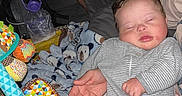 Karsten is registered to the contest to win money with this photo: baby, sleeping, onesie, striped_clothing, blanket, teddy_bear_pattern, toy, colorful, hand, infant, face, indoor, nap, child, soft_toy, resting, cute, young_child, peaceful, portrait