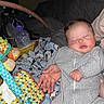 baby, sleeping, onesie, striped_clothing, blanket, teddy_bear_pattern, toy, colorful, hand, infant, face, indoor, nap, child, soft_toy, resting, cute, young_child, peaceful, portrait