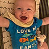 baby, infant, smiling, blue_onesie, fish_graphic, text_on_clothing, blanket, plush_toy, happy, arms_outstretched, close_up, face, cute, child, indoor, laying_down, soft_toy, patterned_blanket, expression, portrait