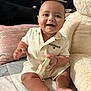 Joshua is registered to the contest to win money with this photo: baby, child, clothing, cute, face, foot, furniture, hand, happy, headwear, indoor, infant, person, pillow, plush_toy, quilt, sitting, smiling, teddy_bear, toy