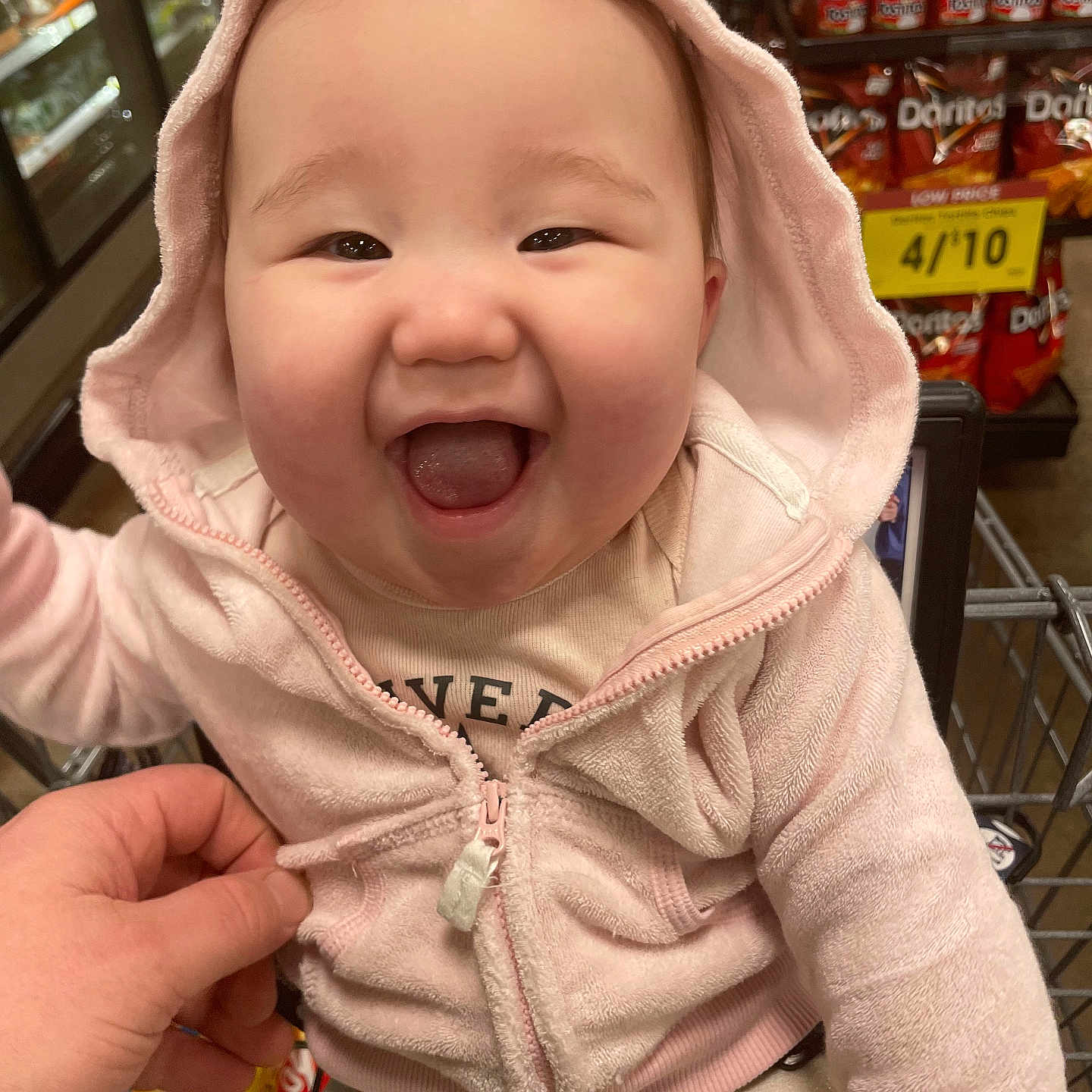 Olivia joined the competition — help win amazing prizes! aisle, baby, child, chips, clothing, cute, grocery_store, hand, happy, hood, infant, joyful, person, pink_hoodie, portrait, retail, retail_shelves, shopping_cart, smiling, snacks
