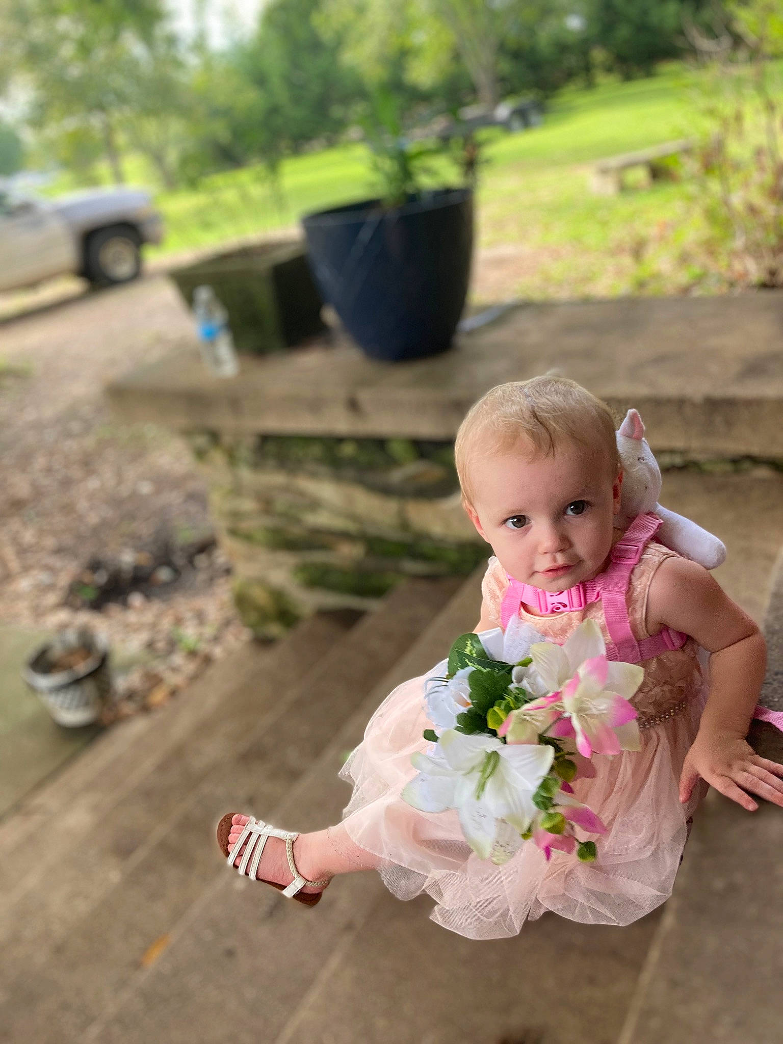 Riley is registered to the contest to win money with this photo: baby, baby_toddler_clothing, child, dress, event, eye, flower, fun, garden, grass, happy, leisure, people_in_nature, person, petal, plant, sitting, tire, toddler, tree