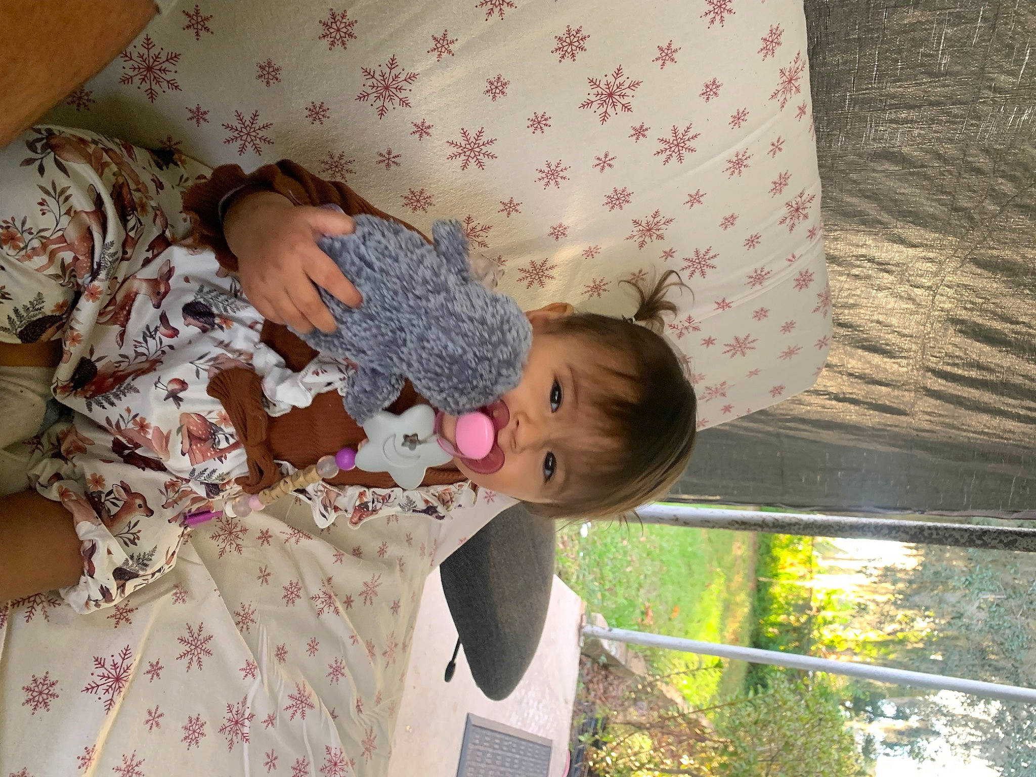 Alaïa is registered to the contest to win money with this photo: baby, baby_toddler_clothing, child, comfort, facial_expression, grass, happy, leisure, linens, magenta, pattern, person, pink, plant, skin, textile, toddler, tree, window