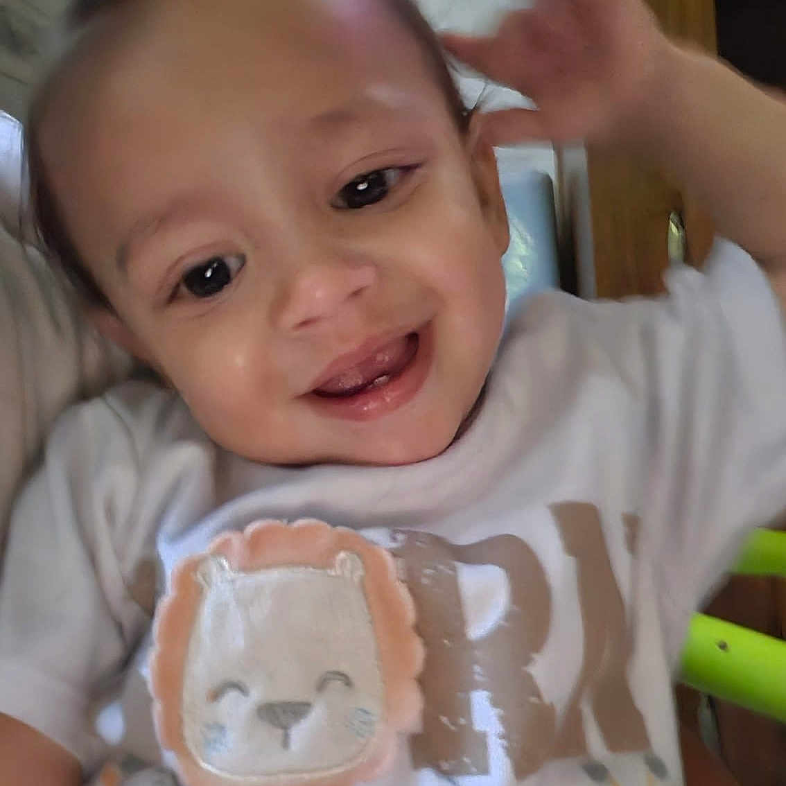 Gabriel joined the competition — help win amazing prizes! baby, infant, child, smiling, waving, portrait, face, eyes, indoor, clothing, onesie, lion_design, animal_print, happy, cute, sitting, close_up, wooden_background, furniture, photography