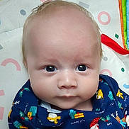 Eric joined the competition — help win amazing prizes! baby, infant, face, close_up, blue_clothing, holiday_print, patterned_blanket, curious, wide_eyes, skin, head, cheeks, indoors, portrait, young_child, child, cute, expression, colorful, soft