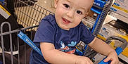 Andrew joined the competition — help win amazing prizes! toddler, shopping_cart, child, smiling, store, aisle, shelves, products, indoor, clothing, handrail, toy, retail, floor, baby, blue_shirt, curly_hair, face, person, happy