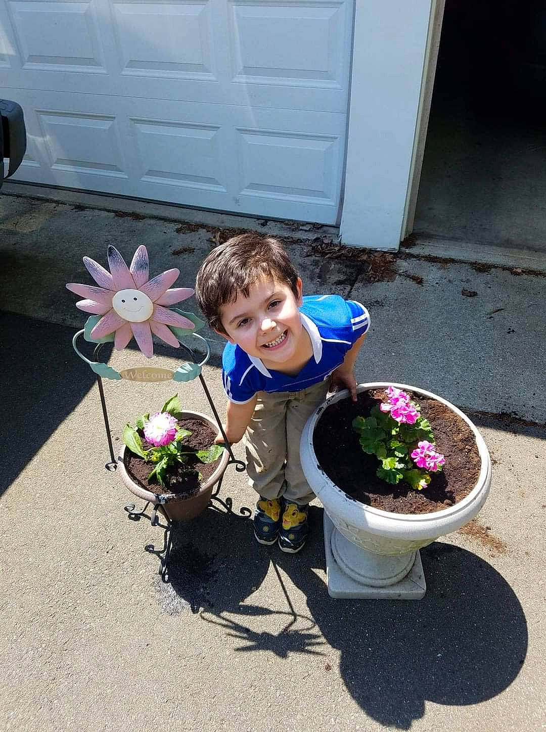 Julien is registered to the contest to win money with this photo: bucket, child, flower, flowerpot, houseplant, joy, person, plant, toddler