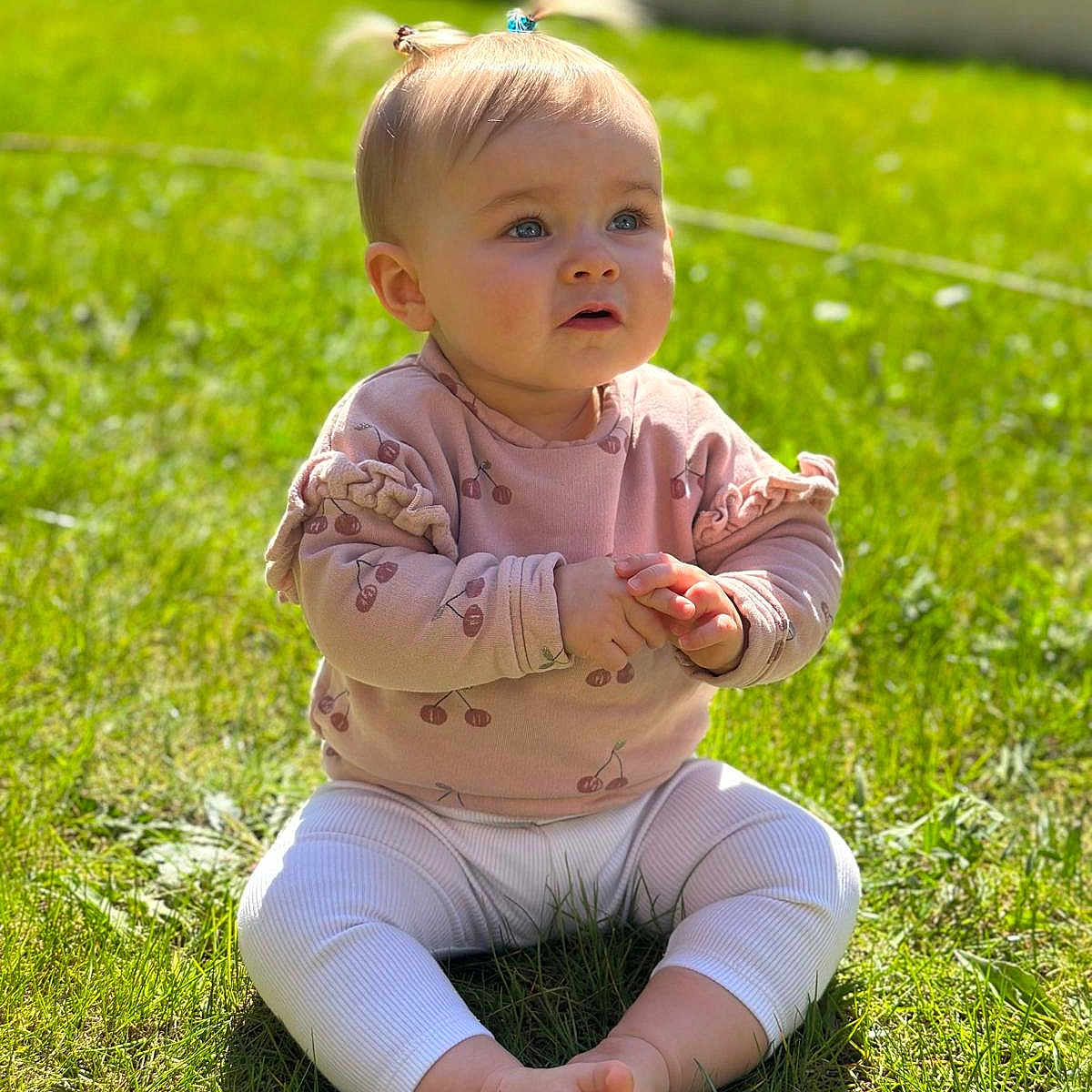 Giulia participe au concours pour gagner de l'argent avec cette photo : baby, blonde, bodypart, clothing, face, finger, fitness, grass, hair, hand, head, lawn, pants, person, photography, plant, portrait, sitting, sleeve, sport