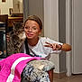 casual_clothing, cat, child, couch, door, floral_pattern, furniture, girl, glasses, hand, home, indoor, peace_sign, pet, portrait, short_hair, smile, tabby_cat, towel, wall