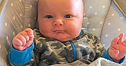 Axel is registered to the contest to win money with this photo: baby, baby_seat, blanket, blue_cuffs, camo, child, comfort, cute, face, hands, head, indoor, infant, onesie, polka_dots, portrait, resting, serious_expression, soft_texture, young