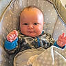 baby, infant, child, onesie, camo, blue_cuffs, blanket, polka_dots, baby_seat, indoor, cute, serious_expression, face, head, hands, soft_texture, comfort, portrait, young, resting