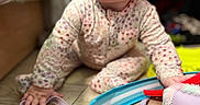 Indie Ana is registered to the contest to win money with this photo: baby, child, closeup, crawling, curious, cute, expression, face, floor, hand, home, indoor, infant, onesie, patterned_clothing, playtime, soft_lighting, toy, wide_eyes, wooden_floor