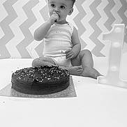 Toby is registered to the contest to win money with this photo: baby, cake, chocolate, sprinkles, birthday, number_one, celebration, messy, sitting, white_background, zigzag_pattern, child, one_year_old, smiling, food, party, cute, indoors, lighting, portrait