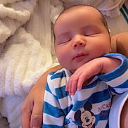 Iwan a rejoint le concours — aidez-le/la à gagner de superbes lots ! baby, sleeping, child, infant, onesie, mickey_mouse, striped_clothing, hand, adult, blanket, soft_texture, cozy, indoor, person, portrait, cute, peaceful, resting, closeup, toddler