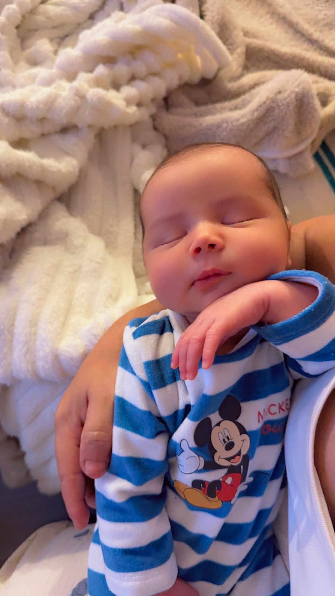 Iwan a rejoint le concours — aidez-le/la à gagner de superbes lots ! baby, sleeping, child, infant, onesie, mickey_mouse, striped_clothing, hand, adult, blanket, soft_texture, cozy, indoor, person, portrait, cute, peaceful, resting, closeup, toddler