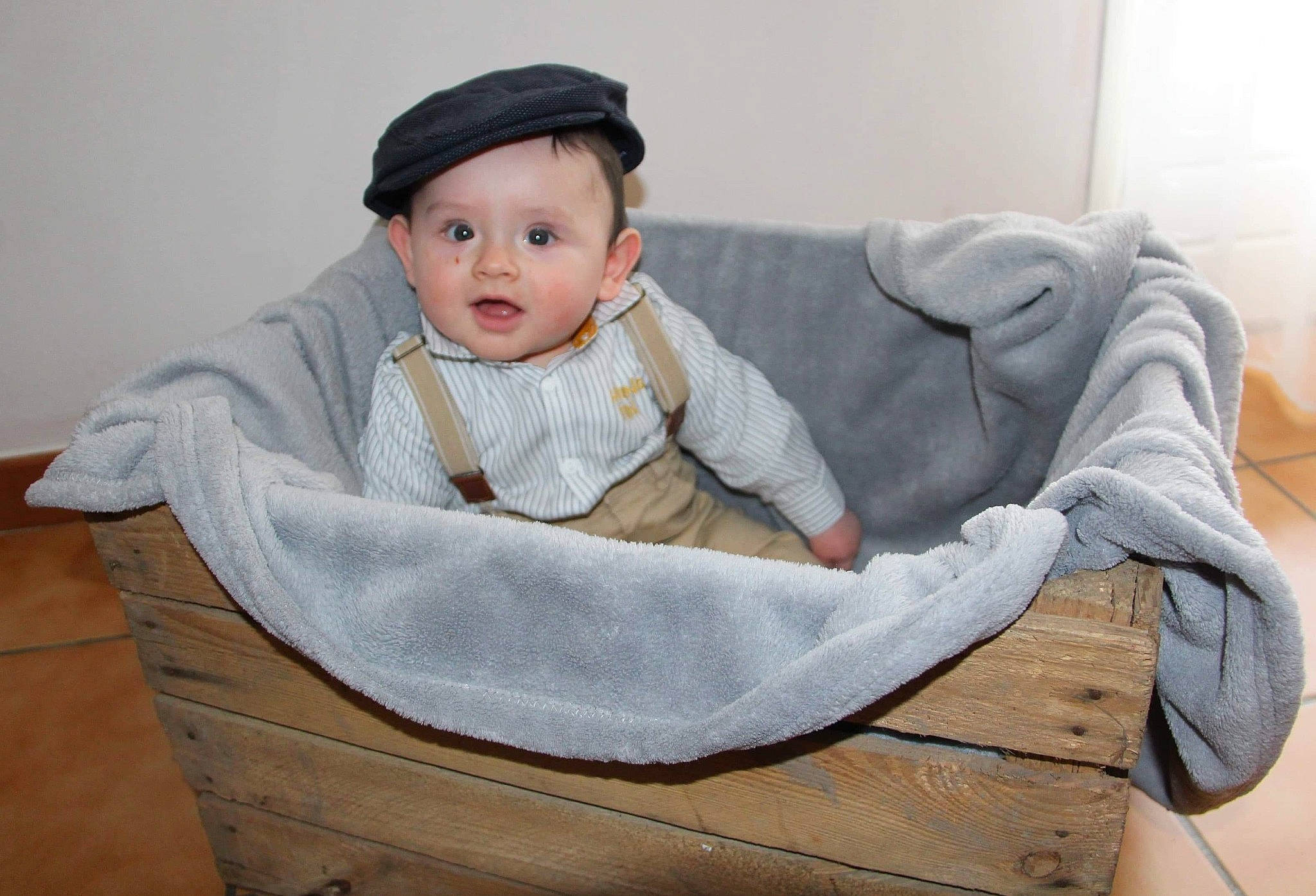 Eddy participe au concours pour gagner de l'argent avec cette photo : baby, baby_toddler_clothing, cap, cheek, child, collar, comfort, fashion_accessory, flooring, fur, headgear, headwear, linens, outerwear, person, sitting, skin, sleeve, smile, toddler
