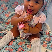 Ahzonni is registered to the contest to win money with this photo: baby, baby_girl, blanket, bow, child, closeup, cute, floral_pattern, happy, headband, indoors, infant, knitted_clothing, pacifier, pink_clothing, playful, portrait, sitting, smiling, white_socks