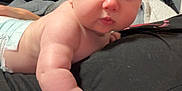 Harper joined the competition — help win amazing prizes! baby, black_fabric, child, chubby_cheeks, close_up, curious, cute, diaper, expression, eyes, face, hand, indoor, infant, lying_down, person, plush, skin, soft, young
