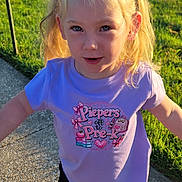 Pieper joined the competition — help win amazing prizes! blonde_hair, casual_clothing, child, daylight, front_view, girl, grass, lawn, outdoor, playful, ponytails, portrait, purple_shirt, sidewalk, smiling, standing, summer, sunlight, sunset, toddler