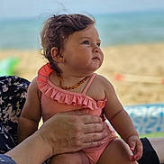 Liyana participe au concours pour gagner de l'argent avec cette photo : baby, child, beach, ocean, swimsuit, pink, hand, adult, outdoor, portrait, summer, toddler, cute, sitting, sea, sunshine, water, vacation, people, skin