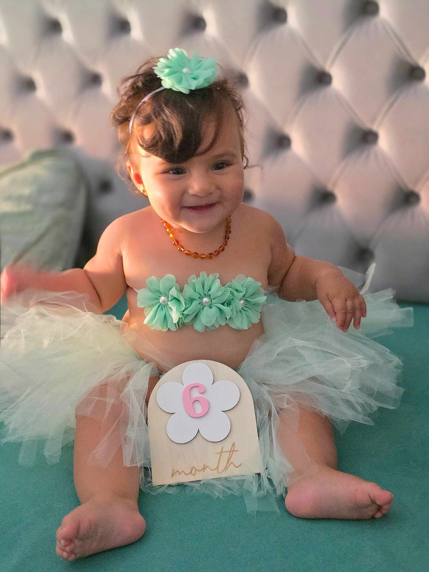 Liyana a rejoint le concours — aidez-le/la à gagner de superbes lots ! baby, infant, smiling, tutu, headband, flower, amber_necklace, milestone, sitting, cute, portrait, soft_lighting, indoor, child, furniture, happy, tulle_skirt, decor, skin, 6_months