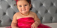 Liyana participe au concours pour gagner de l'argent avec cette photo : baby, barefoot, bed, child, cute, happy, headband, indoor, infant, jewelry, milestone, months, person, portrait, red_dress, sign, sitting, smile, tufted_headboard, tulle