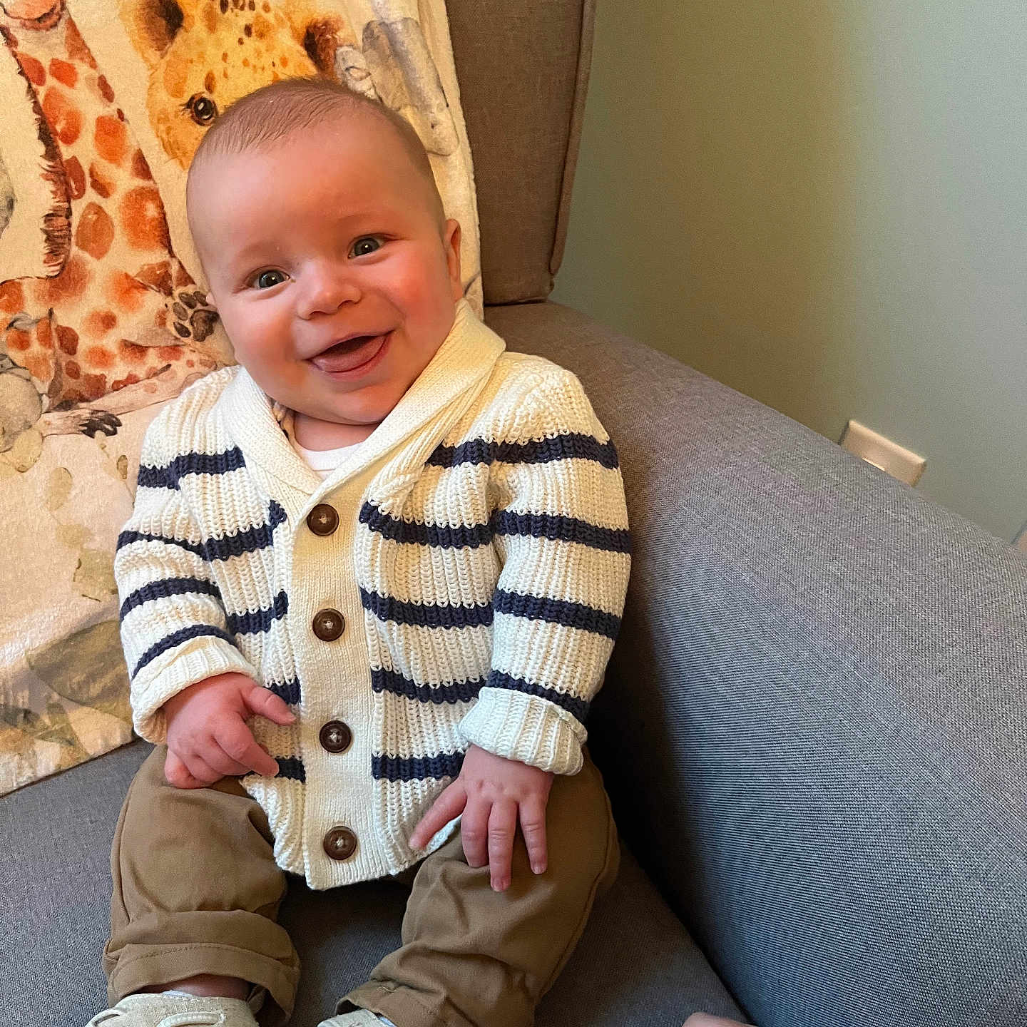 Hayden joined the competition — help win amazing prizes! animal, baby, babylaughing, clothing, couch, cushion, face, furniture, giraffe, happy, head, knitwear, panther, pants, person, photography, portrait, sitting, smile, sweater