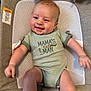 baby, smiling, infant, onesie, green_clothing, cushion, mesh, happy, child, person, cute, skin, face, head, arm, leg, indoor, closeup, text_on_clothing, seated