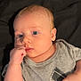 baby, infant, child, blue_eyes, gray_shirt, adidas_logo, hand, thumb, lying_down, curious, portrait, cute, casual_clothing, skin, face, young, indoors, soft_lighting, expression, person