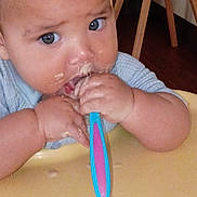 Jamahl joined the competition — help win amazing prizes! baby, child, spoon, food, messy, high_chair, hands, face, blue_eyes, clothing, wooden_chair, table, feeding, eating, cute, indoor, infant, person, closeup, expression