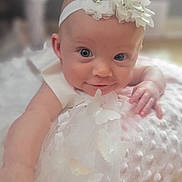 Magnolia joined the competition — help win amazing prizes! baby, infant, child, headband, flower, dress, butterfly, blanket, soft_texture, cute, portrait, smile, indoor, young_child, resting, hand, face, eyes, skin, adorable