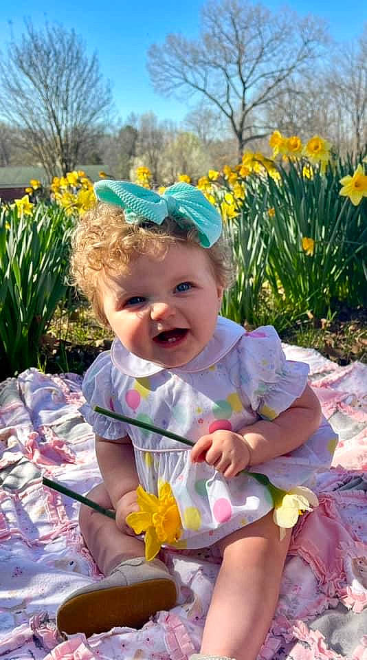 Lucy joined the competition — help win amazing prizes! baby, baby_toddler_clothing, child, facial_expression, flower, fun, grass, happy, iris, leisure, meadow, people_in_nature, person, plant, recreation, sitting, sky, smile, toddler, tree