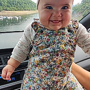Melina Gisel a rejoint le concours — aidez-le/la à gagner de superbes lots ! baby, child, smiling, headband, bow, floral_outfit, car_interior, hand_holding, lake_view, green_hills, window, seat, footwear, cute, portrait, happy, person, indoors, nature, scenic_view