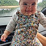 baby, child, smiling, headband, bow, floral_outfit, car_interior, hand_holding, lake_view, green_hills, window, seat, footwear, cute, portrait, happy, person, indoors, nature, scenic_view
