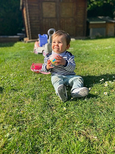Meven a rejoint le concours — aidez-le/la à gagner de superbes lots ! baby, baby_toddler_clothing, ball, botany, fun, grass, grass_family, grassland, groundcover, happy, joy, lawn, leaf, leisure, people_in_nature, person, plant, recreation, sitting, smile