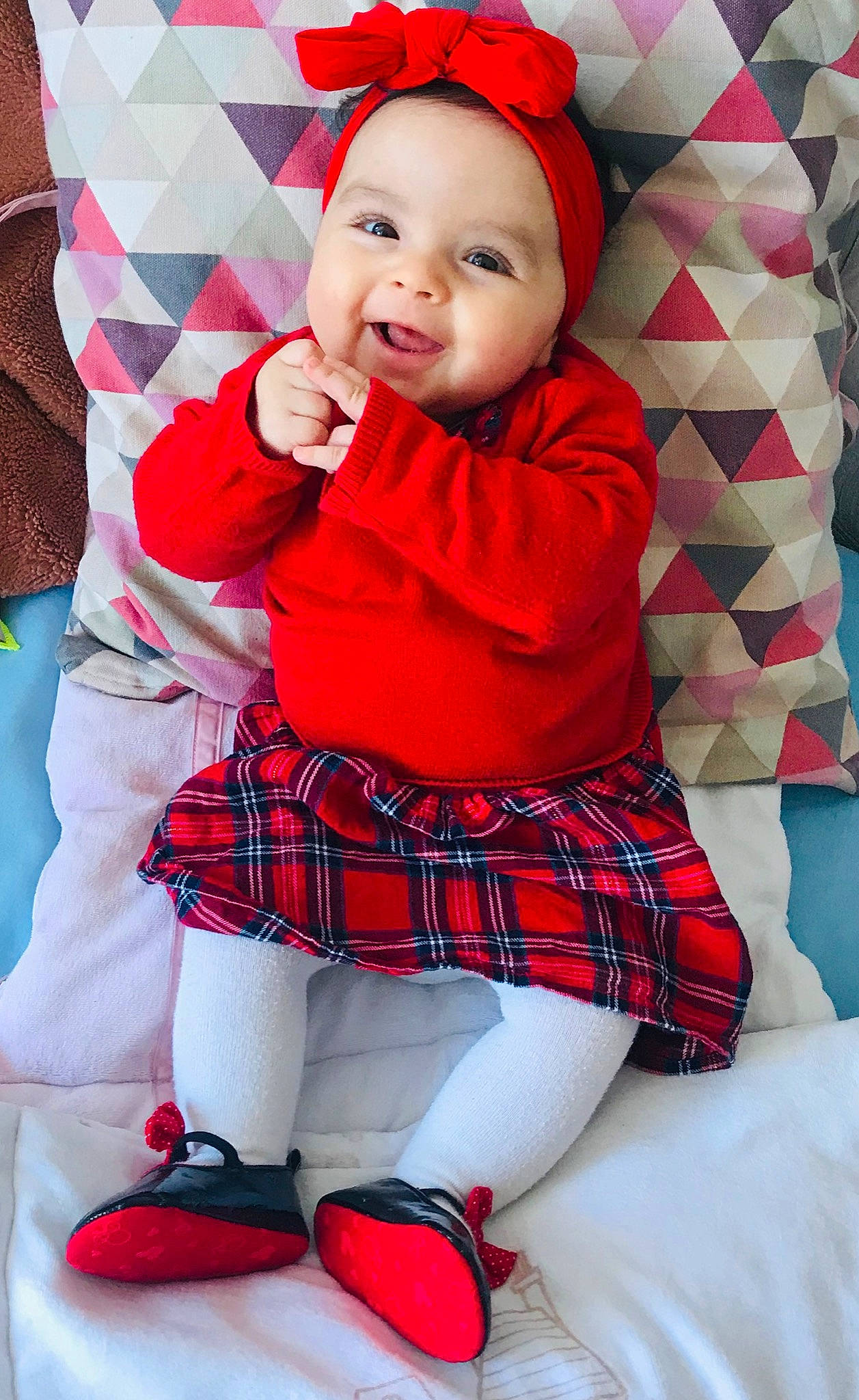 Zahra a rejoint le concours — aidez-le/la à gagner de superbes lots ! baby, baby_toddler_clothing, collar, face, facial_expression, happy, headwear, human_body, knee, pattern, person, photograph, pink, plaid, red, sleeve, smile, sock, tartan, textile