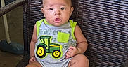 Wyatt is registered to the contest to win money with this photo: baby, chair, child, curious, cute, face, foot, gray_clothing, green, hand, indoor, infant, onesie, person, portrait, sitting, skin, tractor, woven_chair, yellow
