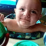 baby, child, smile, high_chair, toy, face, indoor, person, furniture, table, arm, head, expression, closeup, colorful, plastic, seat, happy, cute, young
