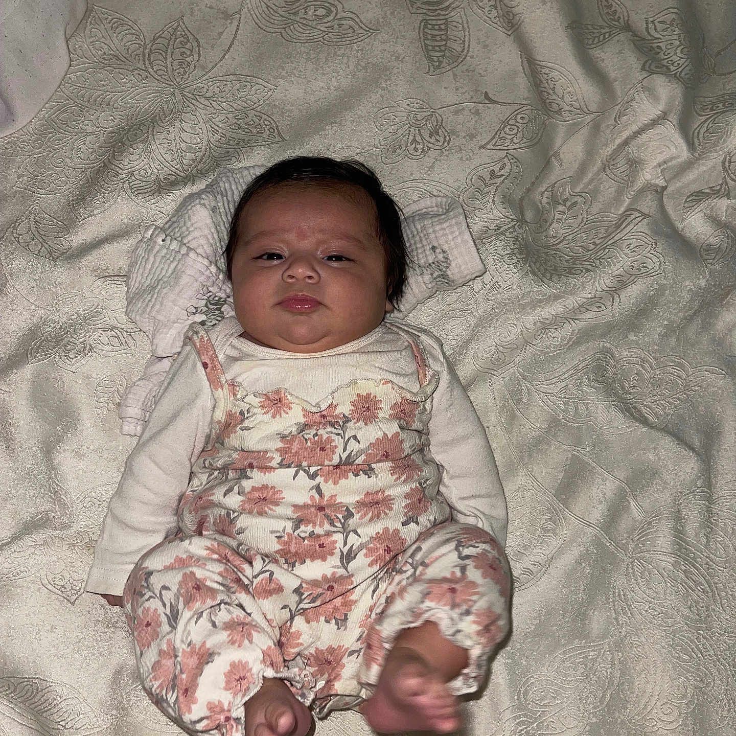 April is registered to the contest to win money with this photo: baby, blanket, child, curious, cute, expression, face, floral_clothing, foot, head, indoors, infant, looking, lying_down, newborn, patterned_blanket, person, sleepwear, small_feet, soft_lighting