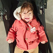 Lina a rejoint le concours — aidez-le/la à gagner de superbes lots ! baby, beige, cheerful, child, clothing, cute, expression, face, happy, indoors, infant, jacket, person, pink, seat, small, smile, stroller, toy, warm