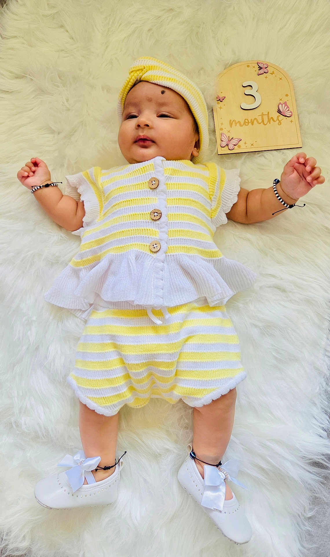 Arvana joined the competition — help win amazing prizes! baby, infant, child, striped_clothing, headband, white_shoes, bow, bracelet, wooden_sign, milestone, butterflies, fluffy_rug, lying_down, cute, portrait, knitted_outfit, yellow_and_white, soft_texture, newborn, adorable