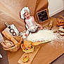 Rosie participe au concours pour gagner de l'argent avec cette photo : baby, child, chef_hat, flour, baking, bread, pastries, basket, rolling_pin, cutting_board, smile, happy, kitchen, floor, apron, sign, food, wooden_spatula, eggs, indoors