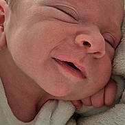 Mathys participe au concours pour gagner de l'argent avec cette photo : newborn, baby, sleeping, smile, face, blanket, soft_texture, closeup, infant, skin, hand, peaceful, comfort, cozy, portrait, child, cute, resting, indoors, warm