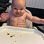 arms, baby, child, chubby, clothing_absent, cute, expression, face, feeding, fisher_price, food, high_chair, indoor, infant, meal, messy, seat, skin, table, tray