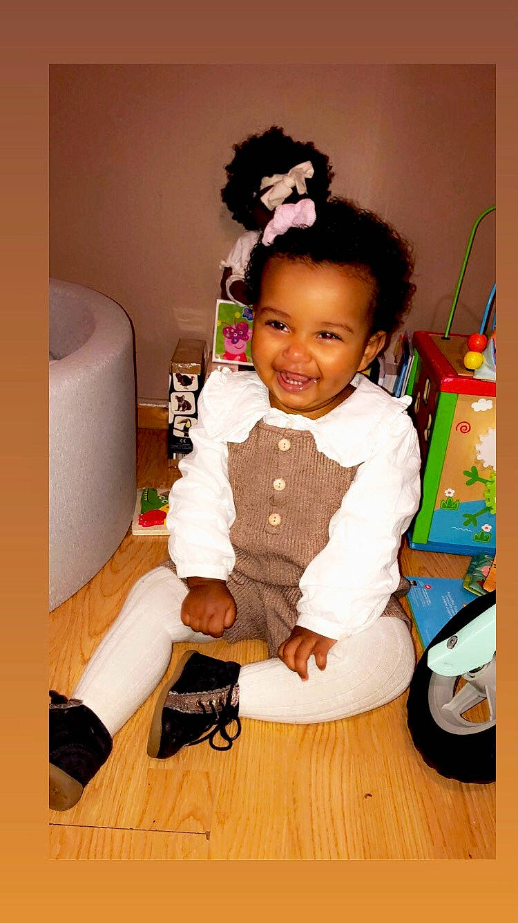 Lya a rejoint le concours — aidez-le/la à gagner de superbes lots ! baby, baby_toddler_clothing, chair, child, costume, event, fashion_design, flooring, fun, happy, hardwood, joy, person, room, sitting, sleeve, smile, sock, tire, toddler