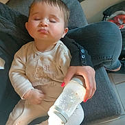 Sasha a rejoint le concours — aidez-le/la à gagner de superbes lots ! baby, bottle, casual, child, clothing, comfort, couch, feeding, floor, footwear, hand, indoor, lap, nail_polish, onesie, person, relaxed, rest, seated, sleepy