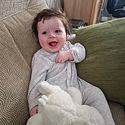 Harley joined the competition — help win amazing prizes! baby, child, couch, cute, furniture, green_pillow, happy, home, indoor, infant, joyful, onesie, person, plush_toy, relaxing, seated, small_child, smiling, soft_toy, stuffed_animal