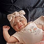 baby, smiling, headband, bow, blanket, lying_down, cute, infant, soft_texture, happy, child, portrait, clothing, pink, sleepy, peaceful, cozy, face, resting, indoors