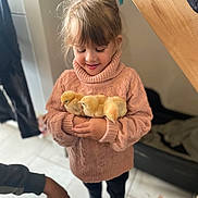 Lola participe au concours pour gagner de l'argent avec cette photo : animal, chicks, child, cozy, cute, floor, fluffy, girl, happy, holding, indoor, person, pet, pink, smile, sweater, tender, toy, warm, yellow