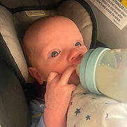 Aidyn joined the competition — help win amazing prizes! baby, infant, bottle, feeding, car_seat, blanket, blue_clothing, hand, face, eyes, newborn, child, indoors, closeup, cute, comfort, resting, star_pattern, soft, person
